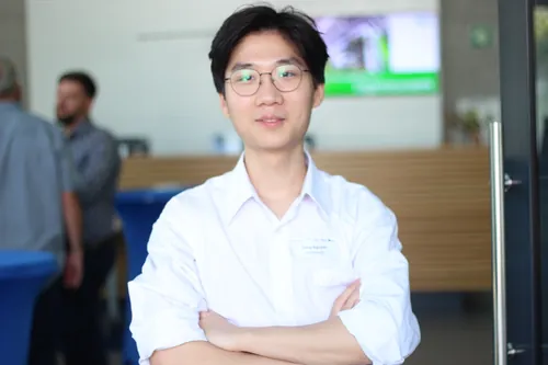 Mann mit Namensschild lehnt an einer Theke und unterhält sich bei einem Networking-Event.