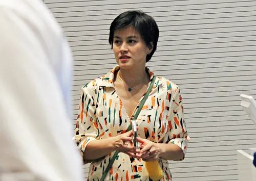 Konferenzteilnehmer im Hörsaal hören einem Vortrag zu und machen sich Notizen.