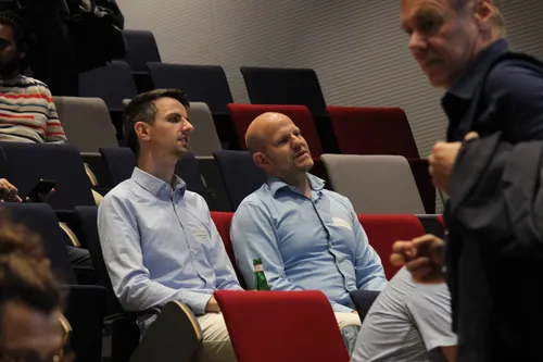 Teilnehmer einer technischen Konferenz im Gespräch während einer Pause.