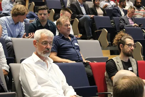 Teilnehmerin einer Fachkonferenz nutzt ihr Smartphone während einer Pause.